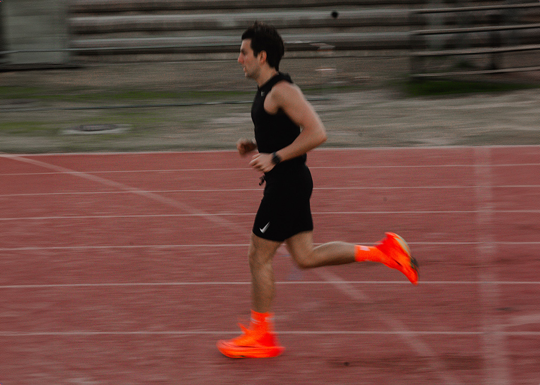 Coach Josh running outside on a track